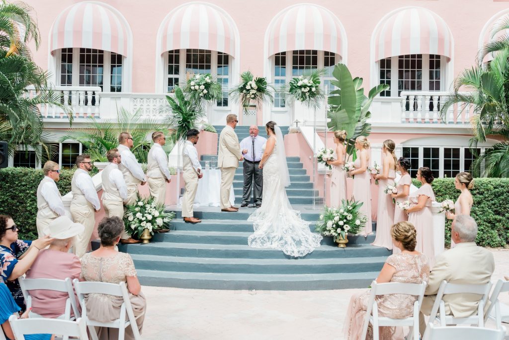 Wedding ceremony with wedding party in front of the Don Cesar Resort Garden