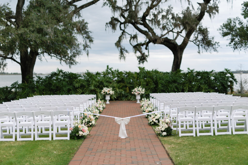 Wedding aisle lined with flowers and tied with ribbon before the ceremony